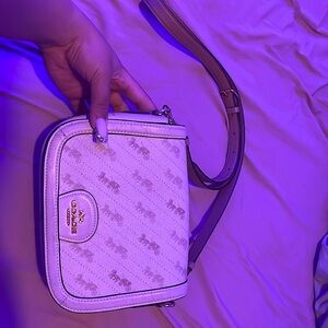 Tan, crème coach purse with gold hardware.